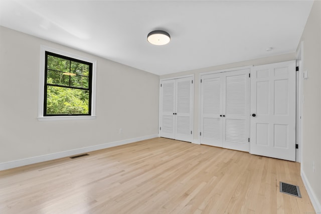 193 Stoner Dr, West Hartford, CT 06107 - unfurnished bedroom featuring two closets and light wood-type flooring