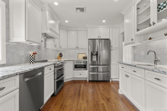 22 Douglas Dr, Norwalk, CT 06850 - kitchen with appliances with stainless steel finishes, white cabinets, tasteful backsplash, dark wood-style flooring, and recessed lighting