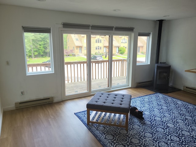 44 Tolland Ave Apt 54, Stafford, CT 06076 - doorway to outside with a baseboard heating unit, a wood stove, and wood finished floors
