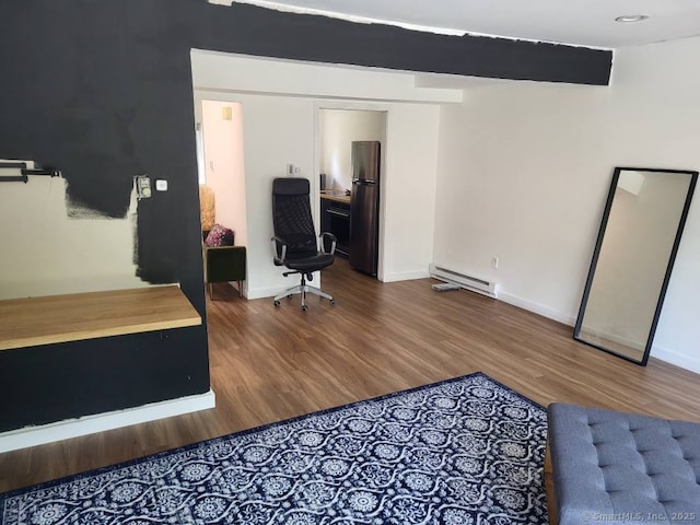 44 Tolland Ave Apt 54, Stafford, CT 06076 - bedroom with a baseboard radiator, freestanding refrigerator, wood finished floors, and baseboards