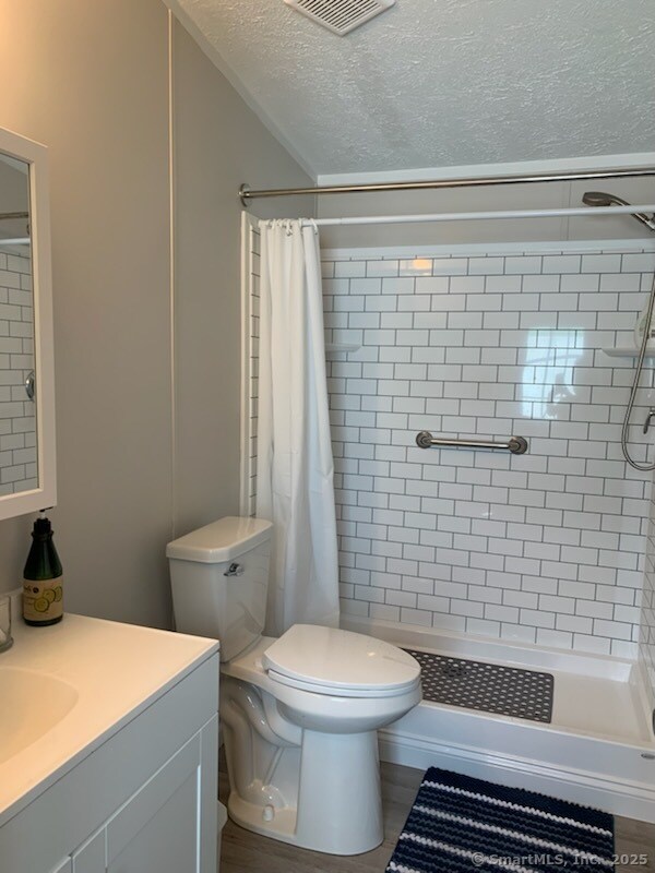1012 Old Colony Rd Lot 8, Meriden, CT 06451 - bathroom with vanity, toilet, a shower stall, and a textured ceiling