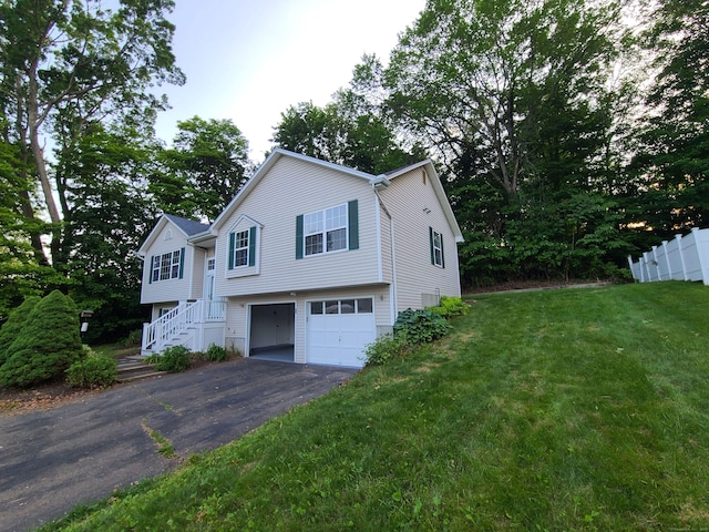24 Wiscassett Ave, Hamden, CT 06518 - split foyer home with asphalt driveway, an attached garage, and a front lawn