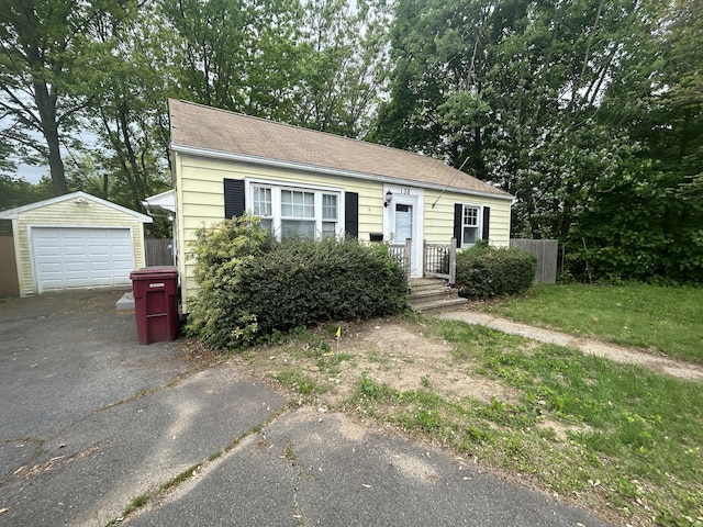 138 Radnor Ave, Naugatuck, CT 06770 - view of front facade featuring asphalt driveway, an outdoor structure, a detached garage, and view of scattered trees