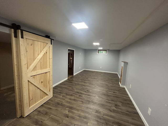 138 Radnor Ave, Naugatuck, CT 06770 - below grade area featuring a barn door, dark wood-style floors, and baseboards
