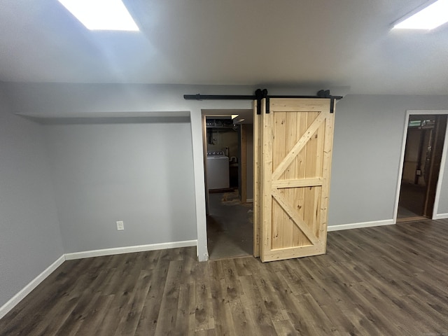 138 Radnor Ave, Naugatuck, CT 06770 - basement featuring washer / clothes dryer, dark wood-type flooring, baseboards, and a barn door