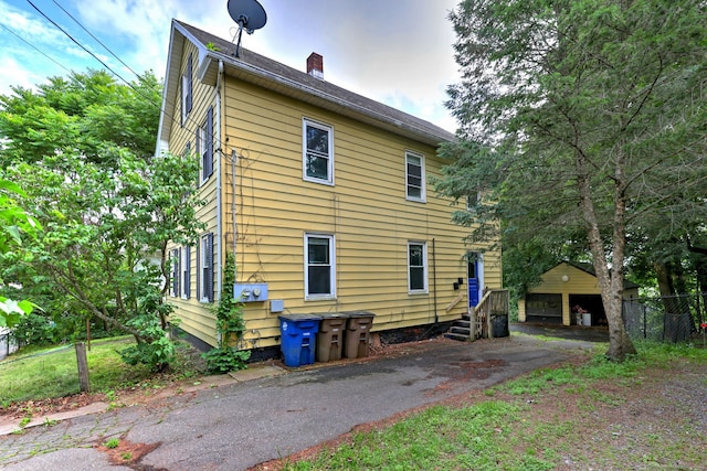 9 Woodland St, Vernon, CT 06066 - rear view of house featuring a chimney and an outbuilding