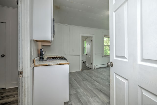 9 Woodland St, Vernon, CT 06066 - kitchen featuring range, a baseboard radiator, white cabinets, crown molding, and light wood-style flooring
