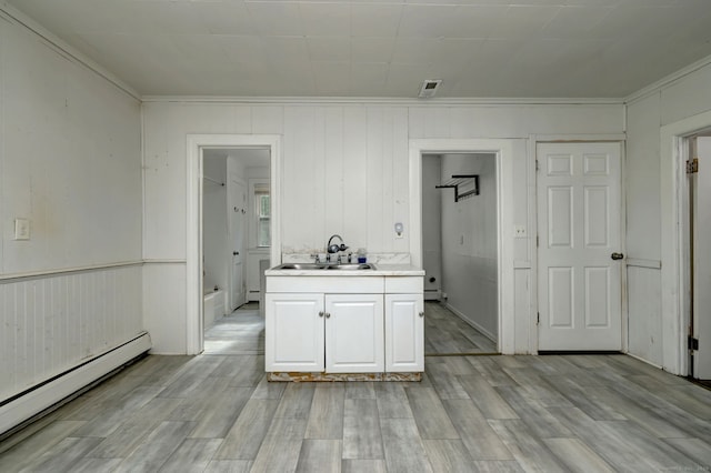 9 Woodland St, Vernon, CT 06066 - kitchen featuring crown molding, baseboard heating, light countertops, light wood-style flooring, and white cabinets