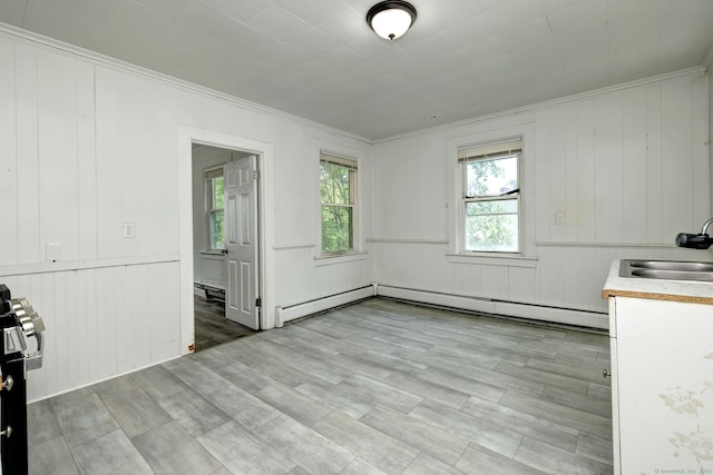 9 Woodland St, Vernon, CT 06066 - unfurnished dining area featuring healthy amount of natural light, crown molding, wooden walls, light wood-type flooring, and a baseboard heating unit