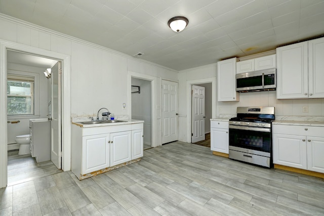 9 Woodland St, Vernon, CT 06066 - kitchen with stainless steel appliances, light countertops, white cabinetry, ornamental molding, and a chandelier