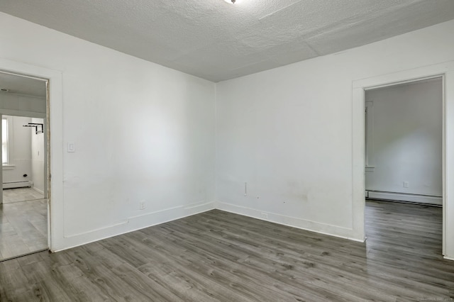 9 Woodland St, Vernon, CT 06066 - spare room featuring a baseboard heating unit, wood finished floors, and a textured ceiling