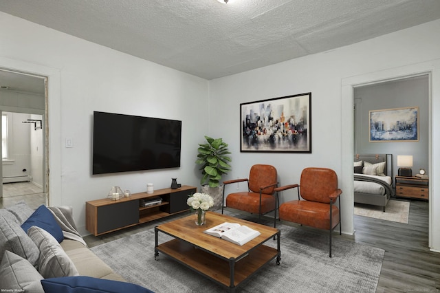 9 Woodland St, Vernon, CT 06066 - living room featuring baseboard heating, wood finished floors, and a textured ceiling