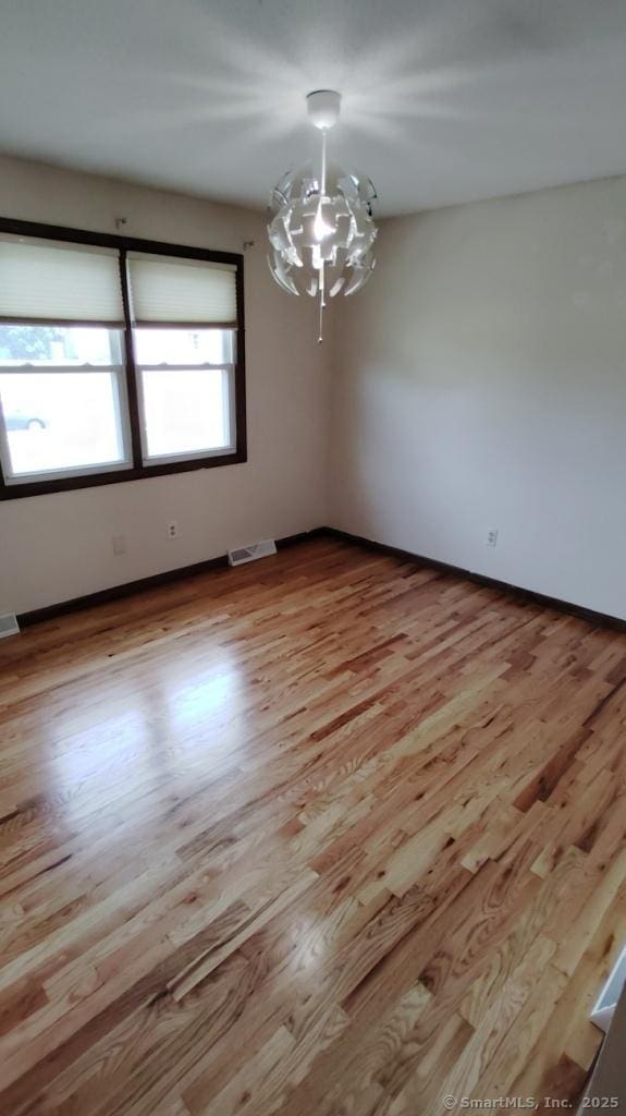 71 Sentinel Hill Rd, North Haven, CT 06473 - empty room featuring a chandelier and light wood-type flooring