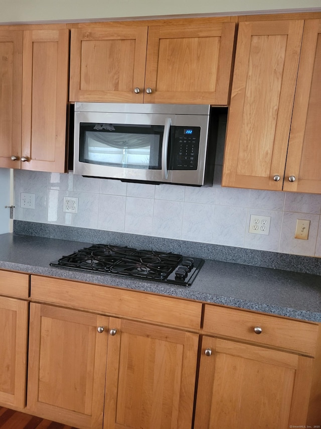 26 King St, Shelton, CT 06484 - kitchen featuring stainless steel microwave, black gas stovetop, dark countertops, and tasteful backsplash