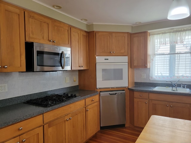 26 King St, Shelton, CT 06484 - kitchen with appliances with stainless steel finishes, a sink, brown cabinetry, and ornamental molding