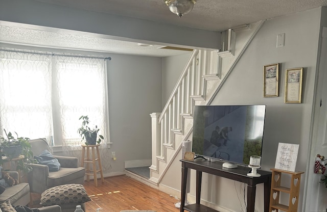 52 Platt St, Bridgeport, CT 06606 - living area featuring healthy amount of natural light, stairway, light wood-style floors, and a textured ceiling