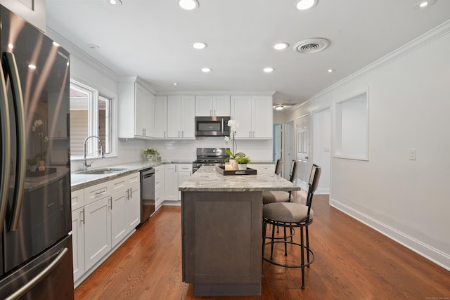 8 Palmer Ln, Oxford, CT 06478 - kitchen featuring stainless steel appliances, ornamental molding, a kitchen breakfast bar, a center island, and white cabinets