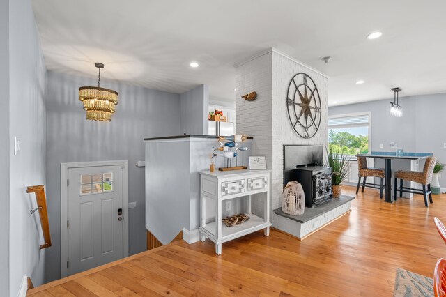49 Economy Dr, Westbrook, CT 06498 - foyer entrance featuring a chandelier, a wood stove, wood finished floors, and recessed lighting