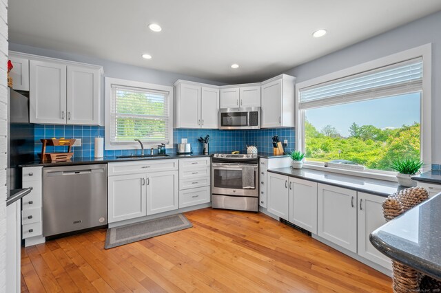 49 Economy Dr, Westbrook, CT 06498 - kitchen featuring appliances with stainless steel finishes, a sink, white cabinetry, tasteful backsplash, and recessed lighting