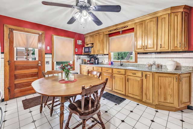 103 Mount Pleasant St, Derby, CT 06418 - kitchen featuring ceiling fan, light stone countertops, decorative backsplash, and brown cabinetry