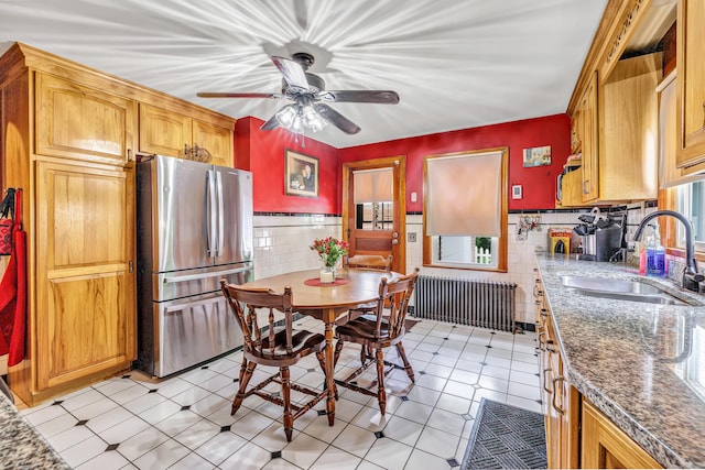 103 Mount Pleasant St, Derby, CT 06418 - kitchen with freestanding refrigerator, radiator heating unit, tile walls, ceiling fan, and a wainscoted wall