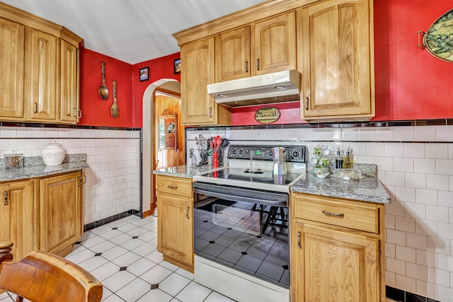 103 Mount Pleasant St, Derby, CT 06418 - kitchen featuring electric range oven, under cabinet range hood, tile walls, arched walkways, and light tile patterned floors