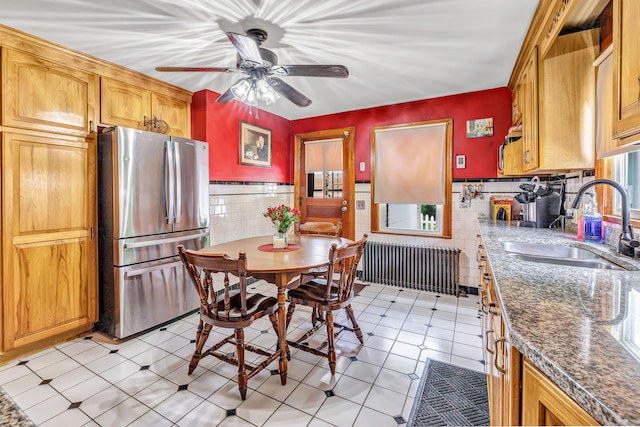 103 Mount Pleasant St, Derby, CT 06418 - kitchen with freestanding refrigerator, radiator heating unit, tile walls, ceiling fan, and wainscoting