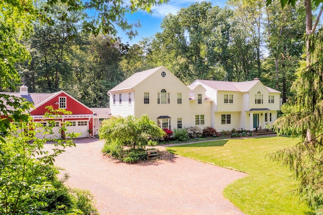17 Joanne Ln, Weston, CT 06883 - view of front facade with dirt driveway, a front lawn, view of scattered trees, and a garage