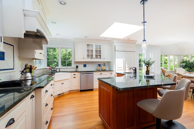 17 Joanne Ln, Weston, CT 06883 - kitchen featuring stainless steel dishwasher, a skylight, a sink, a kitchen breakfast bar, and tasteful backsplash