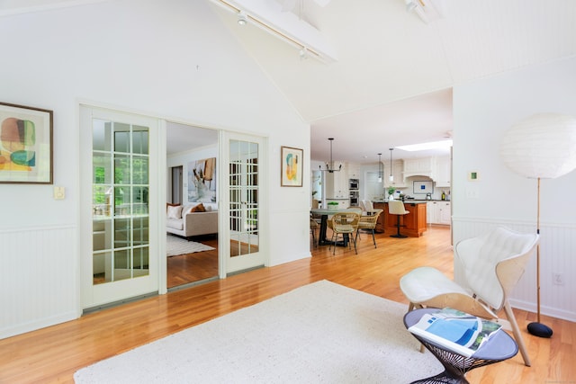 17 Joanne Ln, Weston, CT 06883 - sitting room featuring rail lighting, french doors, a wainscoted wall, light wood finished floors, and lofted ceiling