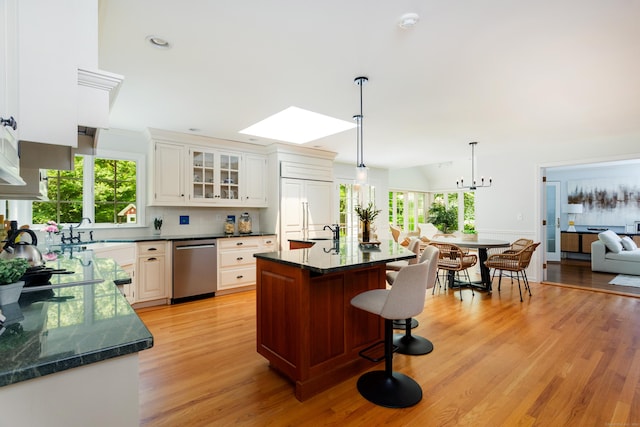 17 Joanne Ln, Weston, CT 06883 - kitchen featuring dishwasher, a breakfast bar area, glass insert cabinets, light wood finished floors, and healthy amount of natural light