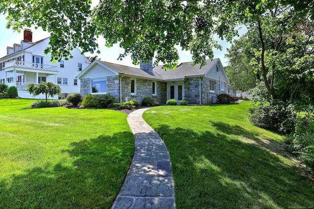 660 Ocean Ave, West Haven, CT 06516 - view of front of house featuring stone siding, a front yard, and a chimney