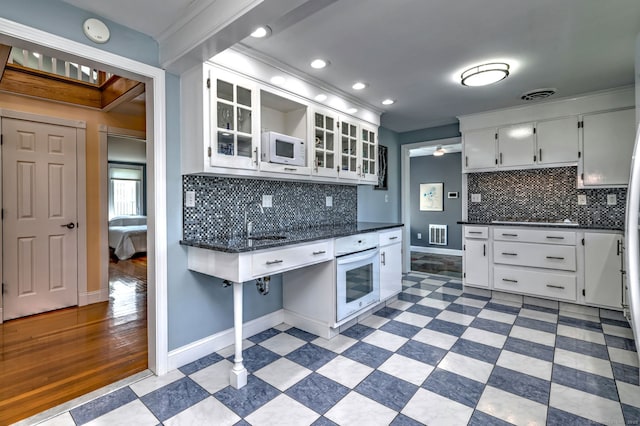 660 Ocean Ave, West Haven, CT 06516 - kitchen featuring white appliances, dark countertops, tasteful backsplash, white cabinetry, and recessed lighting