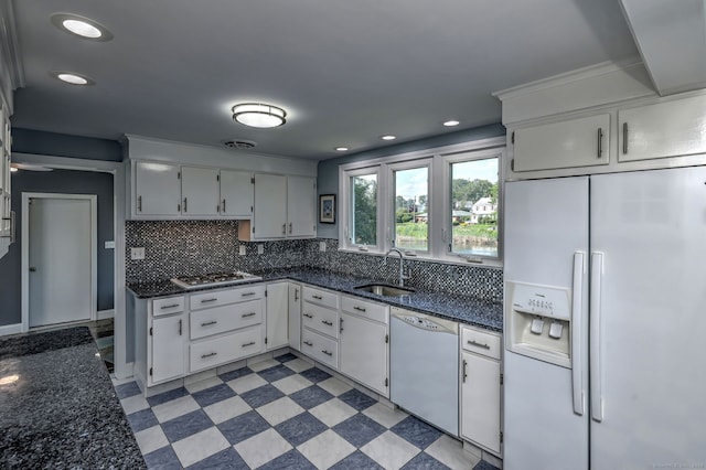 660 Ocean Ave, West Haven, CT 06516 - kitchen with white appliances, backsplash, dark stone countertops, recessed lighting, and white cabinetry