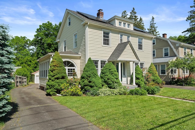 1748 Whitney Ave, Hamden, CT 06517 - view of front of property with solar panels, a chimney, and a front lawn