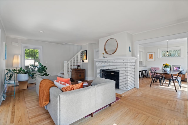 1748 Whitney Ave, Hamden, CT 06517 - living room featuring stairs, a brick fireplace, light wood-style floors, and ornamental molding