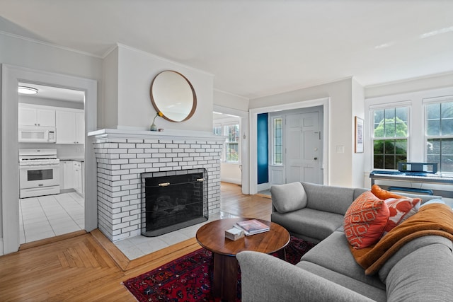 1748 Whitney Ave, Hamden, CT 06517 - living room featuring crown molding, a brick fireplace, light wood finished floors, and baseboards