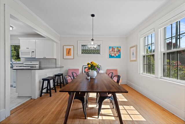 1748 Whitney Ave, Hamden, CT 06517 - dining area featuring light wood finished floors, ornamental molding, and baseboards