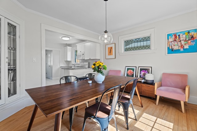 1748 Whitney Ave, Hamden, CT 06517 - dining space featuring light wood-style floors, crown molding, and baseboards