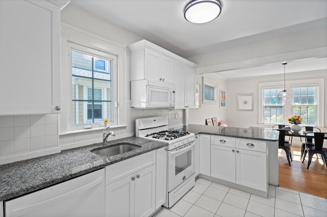 1748 Whitney Ave, Hamden, CT 06517 - kitchen with white appliances, a sink, a peninsula, white cabinetry, and light tile patterned flooring