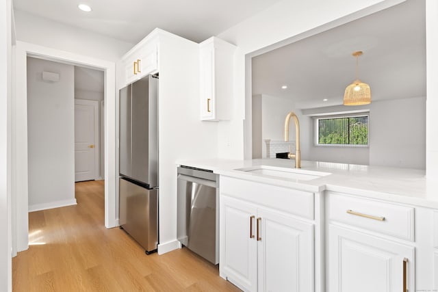 156 Apache Ln Unit A, Stratford, CT 06614 - kitchen with stainless steel appliances, a sink, light wood-style flooring, light countertops, and white cabinets