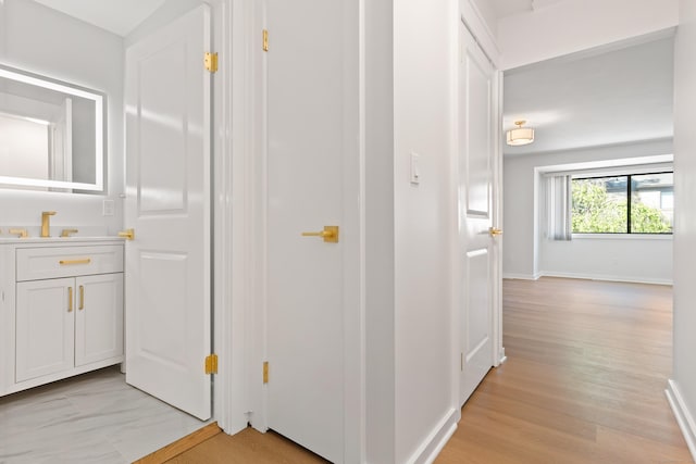156 Apache Ln Unit A, Stratford, CT 06614 - hallway with baseboards, a sink, and light wood finished floors