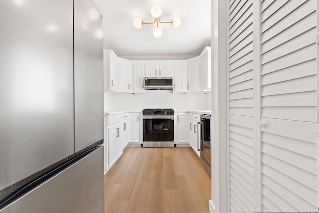 156 Apache Ln Unit A, Stratford, CT 06614 - kitchen featuring appliances with stainless steel finishes, light wood-style floors, white cabinets, and light countertops