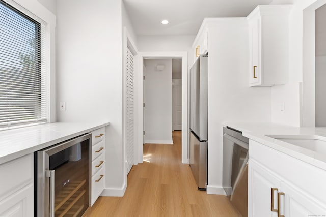 156 Apache Ln Unit A, Stratford, CT 06614 - kitchen featuring wine cooler, stainless steel appliances, light wood finished floors, recessed lighting, and white cabinets