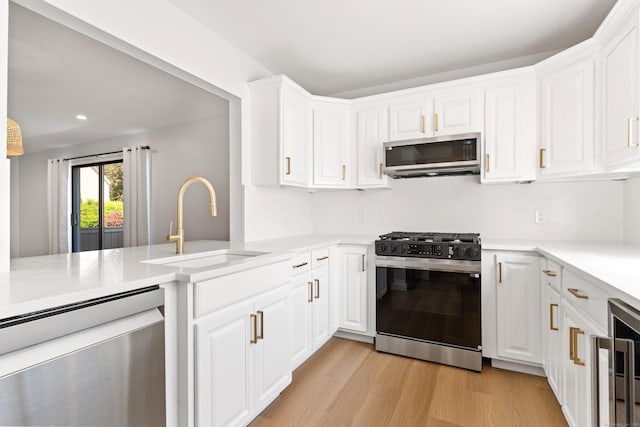 156 Apache Ln Unit A, Stratford, CT 06614 - kitchen featuring appliances with stainless steel finishes, a sink, light wood-type flooring, light countertops, and recessed lighting