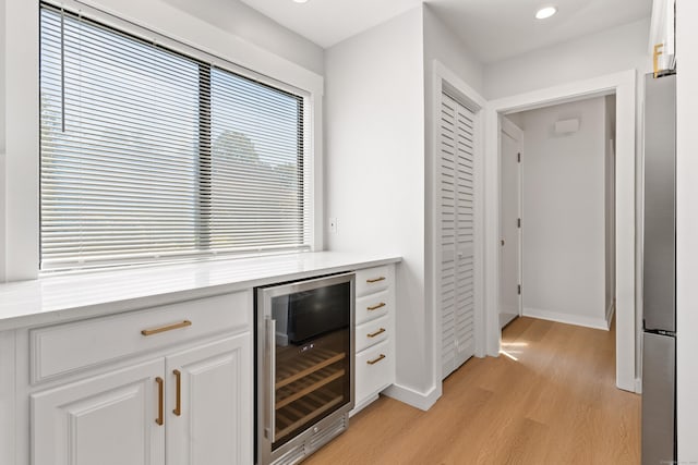 156 Apache Ln Unit A, Stratford, CT 06614 - bar featuring beverage cooler, light wood-style floors, baseboards, recessed lighting, and freestanding refrigerator