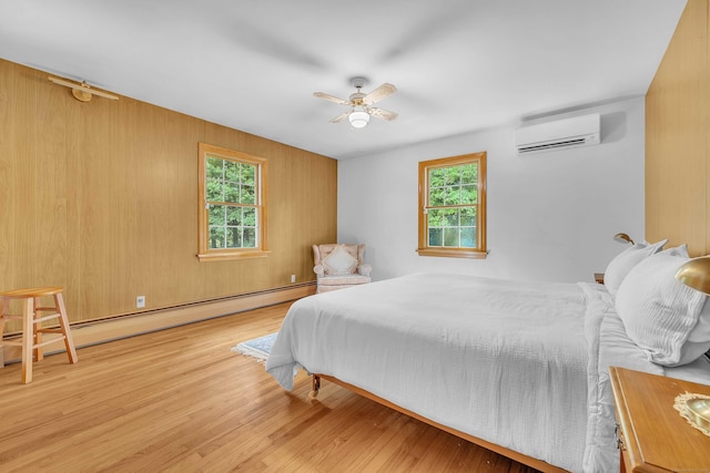 566 Beach Pond Rd, Voluntown, CT 06384 - bedroom featuring an AC wall unit, a baseboard radiator, multiple windows, and wood finished floors