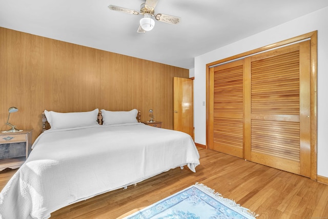 566 Beach Pond Rd, Voluntown, CT 06384 - bedroom with light wood finished floors, a closet, a ceiling fan, and wood walls