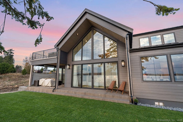 70 S Lake Shore Dr, Brookfield, CT 06804 - back of house at dusk with a balcony, a lawn, and a patio area