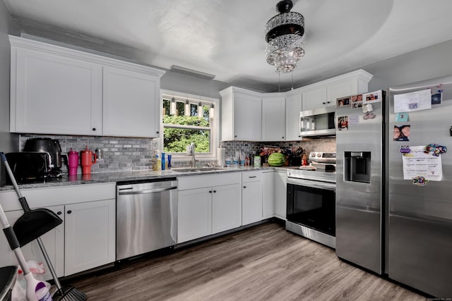 22 Hillside Ave, Torrington, CT 06790 - kitchen with appliances with stainless steel finishes, a sink, stone counters, white cabinetry, and backsplash